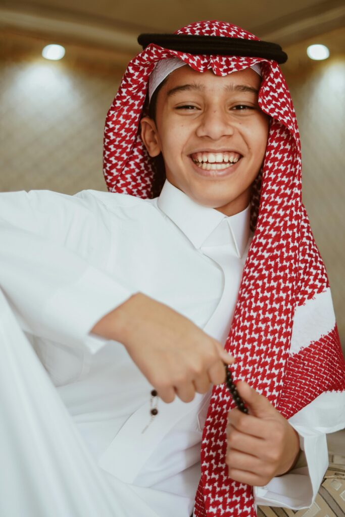 Smiling Arab teenager wearing traditional clothing, showcasing cultural heritage.